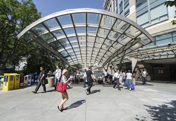 people walking outside of a building under an overpass at West End Residences, Washington